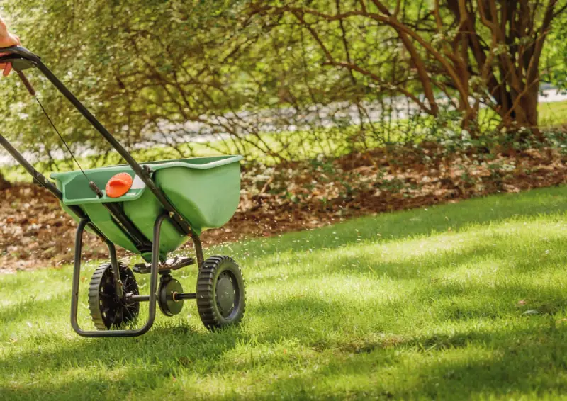 Landscaper fertilizing lawn