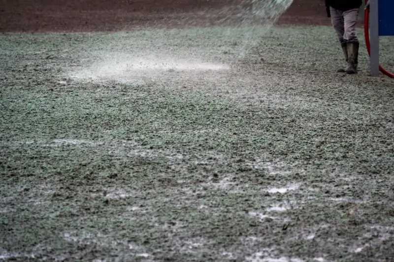 Landscaper hydroseeding a lawn.