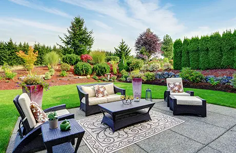 Backyard patio with furniture surrounded by greenery